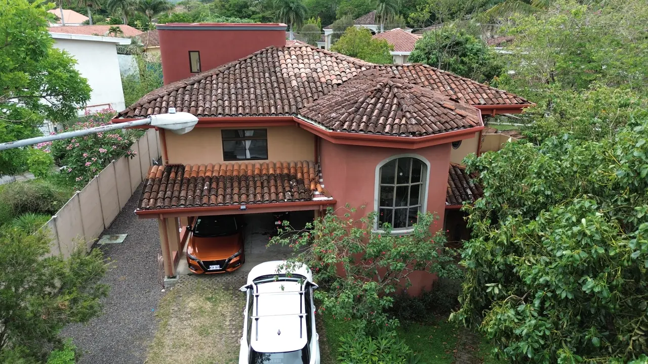 Casa de estilo colonial costarricense con techo de teja en Santa Ana, vista desde el jardín