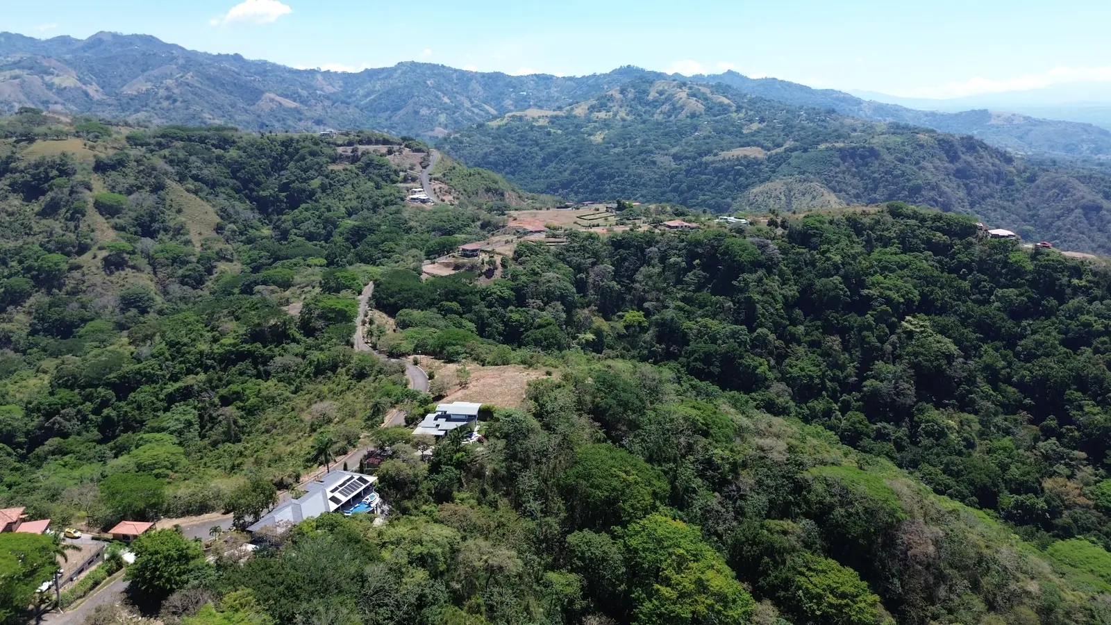 Terreno con vegetación y montañas del Valle Central al fondo, vista aérea